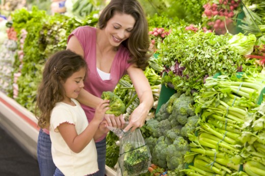 Mother and daughter shopping for produce in supermarket