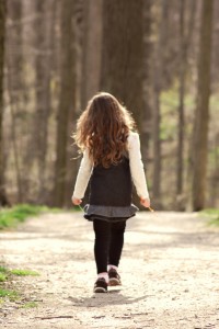 A little girl walking in the woods