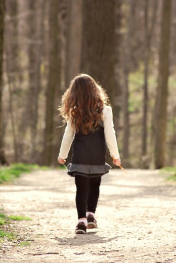 A little girl walking in the woods