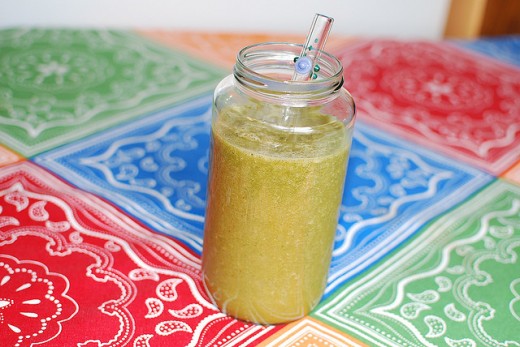 green smoothie in mason jar with glass straw