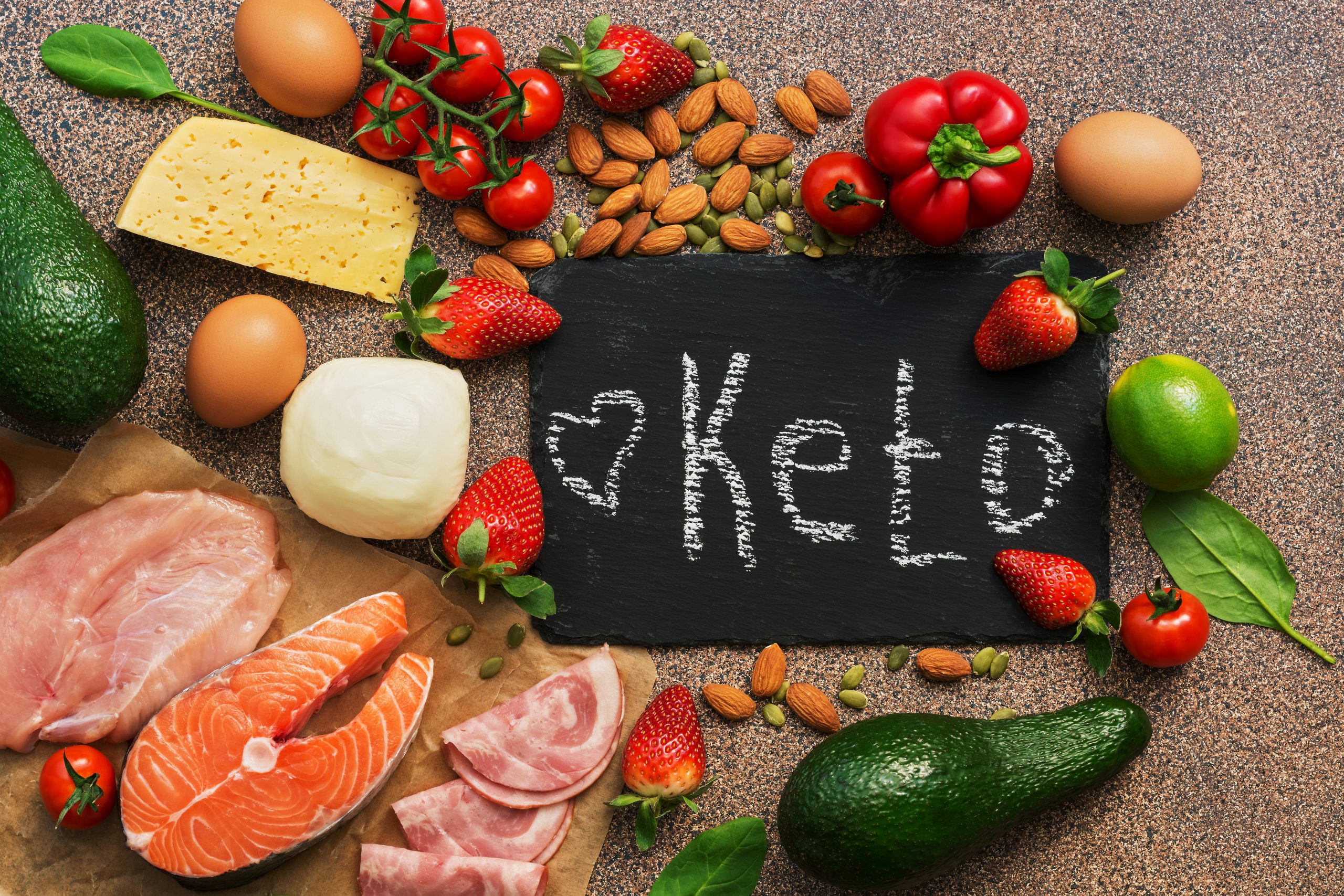 Keto diet food. Healthy low carbs products.Keto diet concept. Vegetables, fish, meat, nuts, seeds, strawberries, cheese on a brown background. Top view. Signboard.